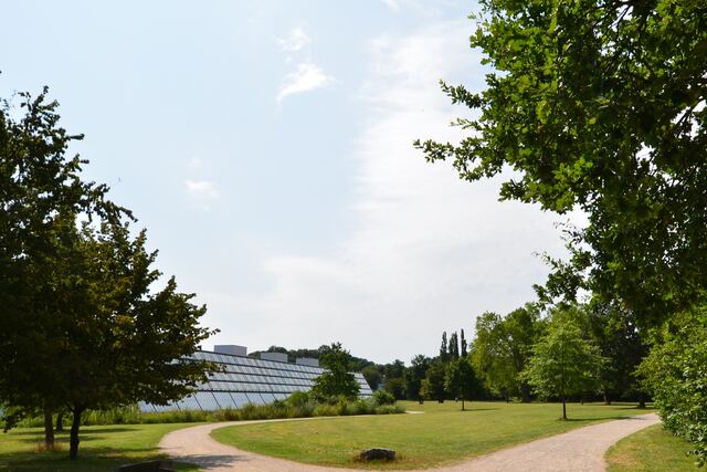 Parkanlage des Wissenschaftsparks mit Wegen und Blick auf die Glasfassade